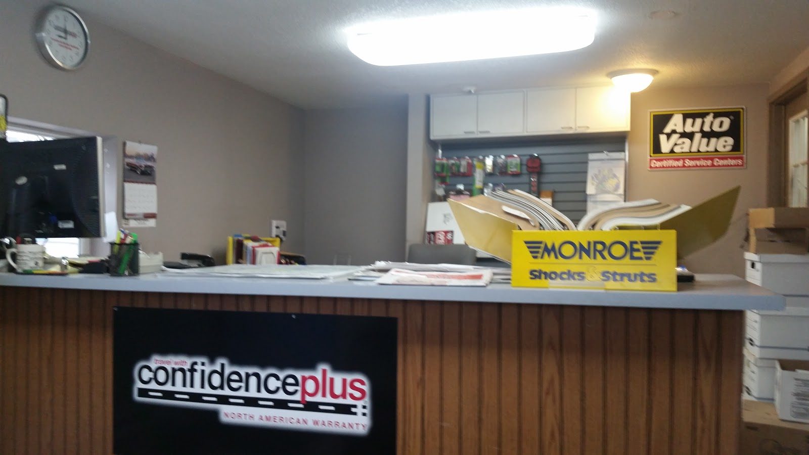 Front counter at Ambler Service & Repair showing Auto Value Certified and ConfidencePlus warranty signs